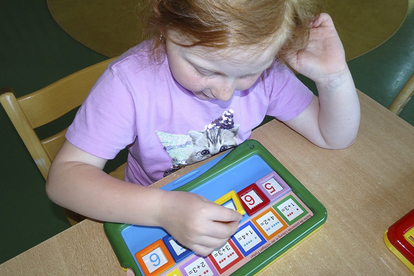 Mädchen arbeitet konzentriert mit einem Lernspiel in der Elemauka Schule